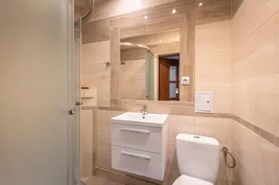 a bathroom with a toilet and a sink and a shower at Queen Apartments in Kraków