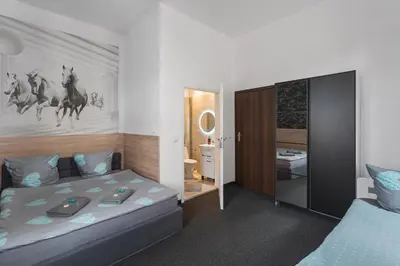 two beds in a room with red pillows at Queen Apartments in Kraków