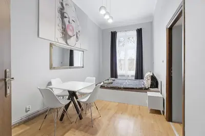 a bedroom with a bed and a table and chairs at Queen Apartments in Kraków