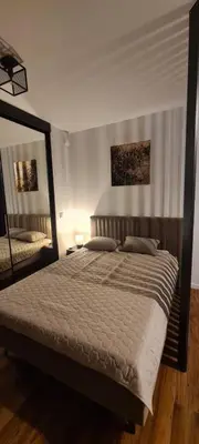 a bedroom with a large bed and a mirror at Rydlowka 21 apartament in Kraków