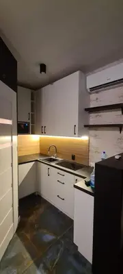 a kitchen with white cabinets and a sink at Rydlowka 21 apartament in Kraków