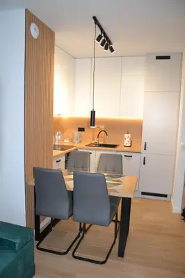 a kitchen with a table with chairs and a sink at Apartament Krakusek Kraków in Kraków
