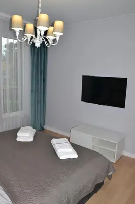 a bedroom with a bed with a tv and a desk at Apartament Krakusek Kraków in Kraków