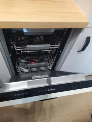an open dishwasher sitting under a table at Apartament Krakusek Kraków in Kraków