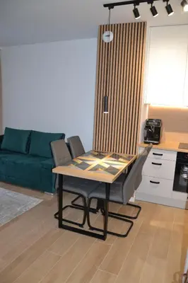 a dining table and chairs in a living room at Apartament Krakusek Kraków in Kraków