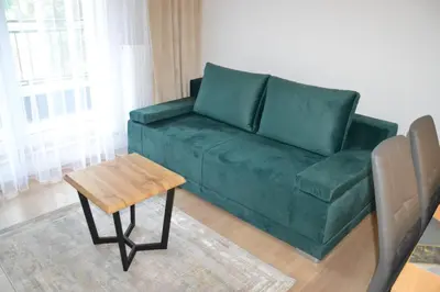 a green couch in a living room with a table at Apartament Krakusek Kraków in Kraków