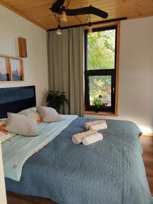 a living room with a couch and a bed at Domek Ponad Mgłami in Laskowa