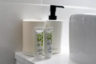 a row of white bottles of cream on a shelf at Malila Premium Apartments Cracow Centre Starowiślna 43 in Kraków