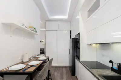 a kitchen with white walls and a counter with plates on it at Malila Premium Apartments Cracow Centre Starowiślna 43 in Kraków