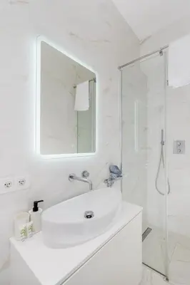 a white bathroom with a sink and a shower at Malila Premium Apartments Cracow Centre Starowiślna 43 in Kraków