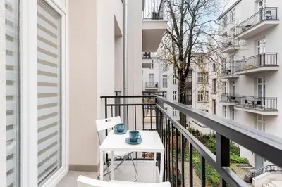 a balcony with a table and two mugs on it at Malila Premium Apartments Cracow Centre Starowiślna 43 in Kraków