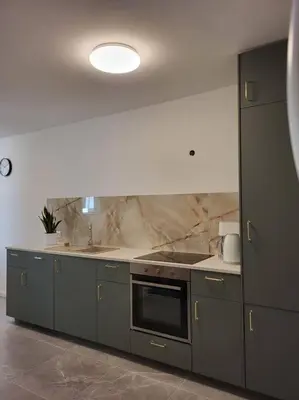 a kitchen with gray cabinets and a stove and sink at Mieszkanie na Starym Podgórzu. in Kraków