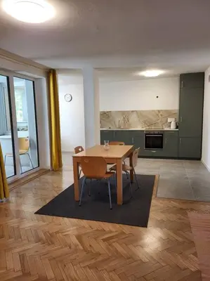 a dining room with a table and a kitchen at Mieszkanie na Starym Podgórzu. in Kraków