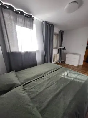 a bedroom with a green bed with a window at Mieszkanie na Starym Podgórzu. in Kraków
