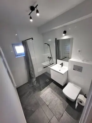 a white bathroom with a toilet and a sink at Mieszkanie na Starym Podgórzu. in Kraków