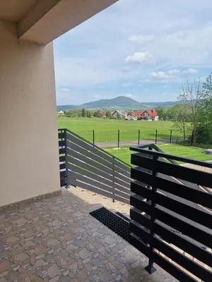 a porch with a fence and a view of a field at Dom w górach in Lipnik