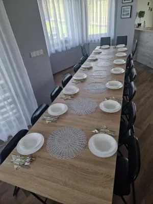 a long wooden table with chairs and plates on it at Dom w górach in Lipnik