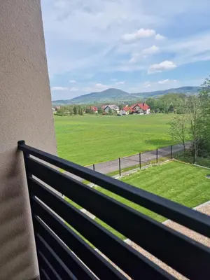 a balcony with a view of a green field at Dom w górach in Lipnik