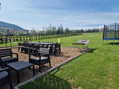 a group of tables and chairs in a field at Dom w górach in Lipnik