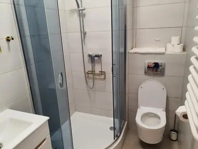 a bathroom with a shower with a toilet and a sink at Old Town OK Apartments in Kraków