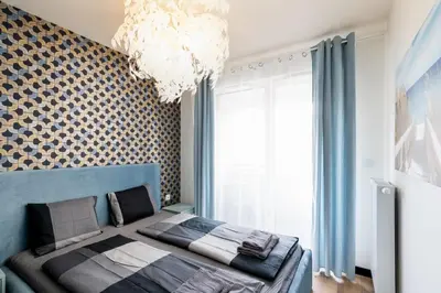 a bedroom with a bed and a chandelier at Dabie Park Residence in Kraków