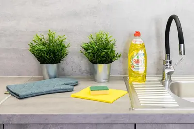 a kitchen counter with a sink and a bottle of cleaning agent at Dabie Park Residence in Kraków