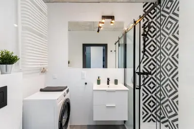 a white laundry room with a washer and dryer at Dabie Park Residence in Kraków