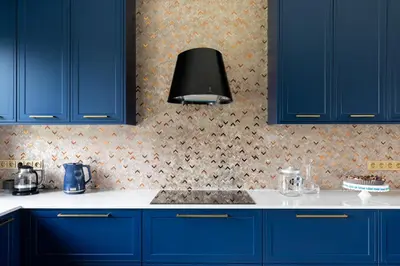 a kitchen with blue cabinets and a black lamp at Granatowy Dom in Stary Wiśnicz