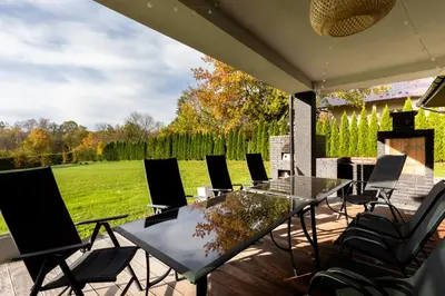 a patio with a glass table and chairs at Granatowy Dom in Stary Wiśnicz