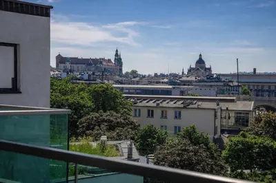 a view of a city from the balcony of a building at InPoint Wawel View Apartments- Free Underground Parking in Kraków