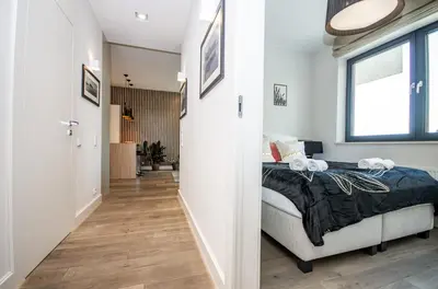 a bedroom with a bed and a hallway at InPoint Wawel View Apartments- Free Underground Parking in Kraków
