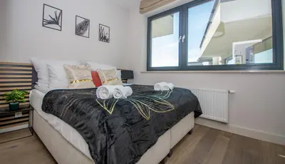 a bedroom with a bed with two towels on it at InPoint Wawel View Apartments- Free Underground Parking in Kraków