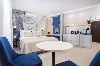a hotel room with a bed and a table and chairs at InPoint Wawel View Apartments- Free Underground Parking in Kraków