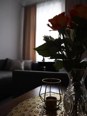 a vase with a rose and a candle on a table at 555 Flat - 55 m² mieszkanie, 5 min - Dworzec Główny in Kraków