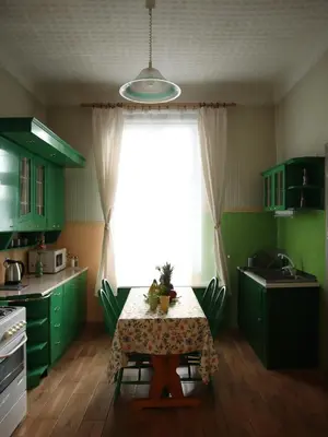 a kitchen with green cabinets and a table and a window at 555 Flat - 55 m² mieszkanie, 5 min - Dworzec Główny in Kraków