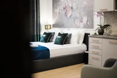 a bedroom with a bed with blue and white pillows at CracWoW K8 Apartments in Kraków