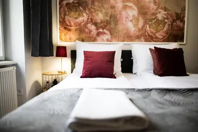 a bedroom with a large bed with red pillows at CracWoW K8 Apartments in Kraków