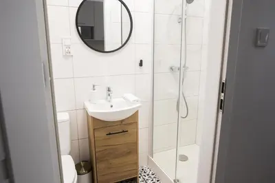 a bathroom with a sink and a shower at CracWoW K8 Apartments in Kraków