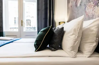 a bed with four pillows on top of it at CracWoW K8 Apartments in Kraków