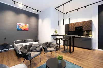 a living room with a couch and chairs and a kitchen at Rainbow Apartments Old Town in Kraków
