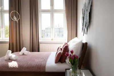 a bedroom with a bed with a window and flowers at Amazing apartament in the heart of Kazimierz in Kraków