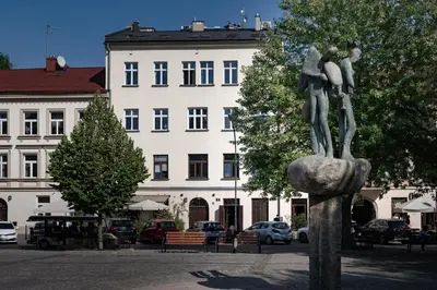a statue of two people on a rock in front of a building at Amazing apartament in the heart of Kazimierz in Kraków