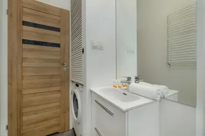a bathroom with a sink and a washing machine at Home Office - 2-Bedroom Apartment Corpo-Stay in Kraków by Noclegi Renters in Kraków