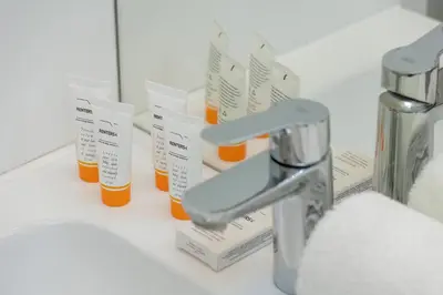 a bathroom sink with a faucet and two bottles of pills at Home Office - 2-Bedroom Apartment Corpo-Stay in Kraków by Noclegi Renters in Kraków