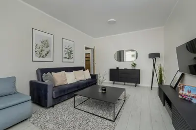 a living room with a couch and a table at Home Office - 2-Bedroom Apartment Corpo-Stay in Kraków by Noclegi Renters in Kraków