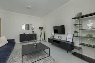 a living room with a couch and a tv at Home Office - 2-Bedroom Apartment Corpo-Stay in Kraków by Noclegi Renters in Kraków