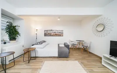 a living room with a bed and a tv at Apart-Studio Close Wawel Castle in Kraków