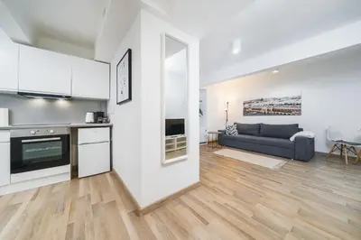 a kitchen and living room with a couch and a table at Apart-Studio Close Wawel Castle in Kraków