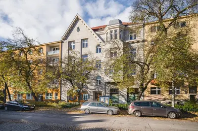 two cars parked in front of a large building at Apart-Studio Close Wawel Castle in Kraków