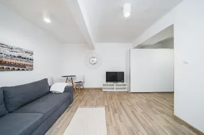 a living room with a couch and a tv at Apart-Studio Close Wawel Castle in Kraków